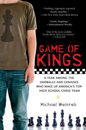 Game of Kings book about top U.S. high school chess teams, next to a person wearing a T-shirt with a chess piece.