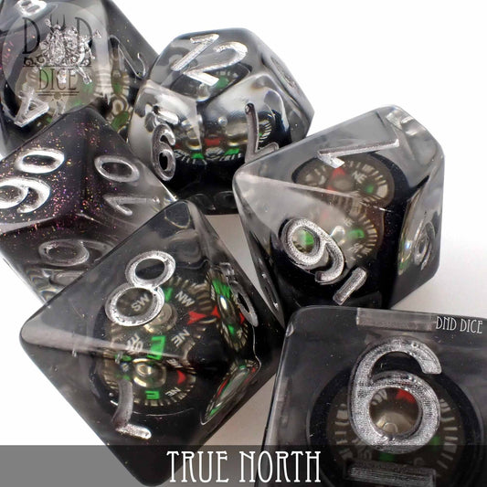 True North 7-piece black resin dice set with a functional compass marked TRUE NORTH on one die.