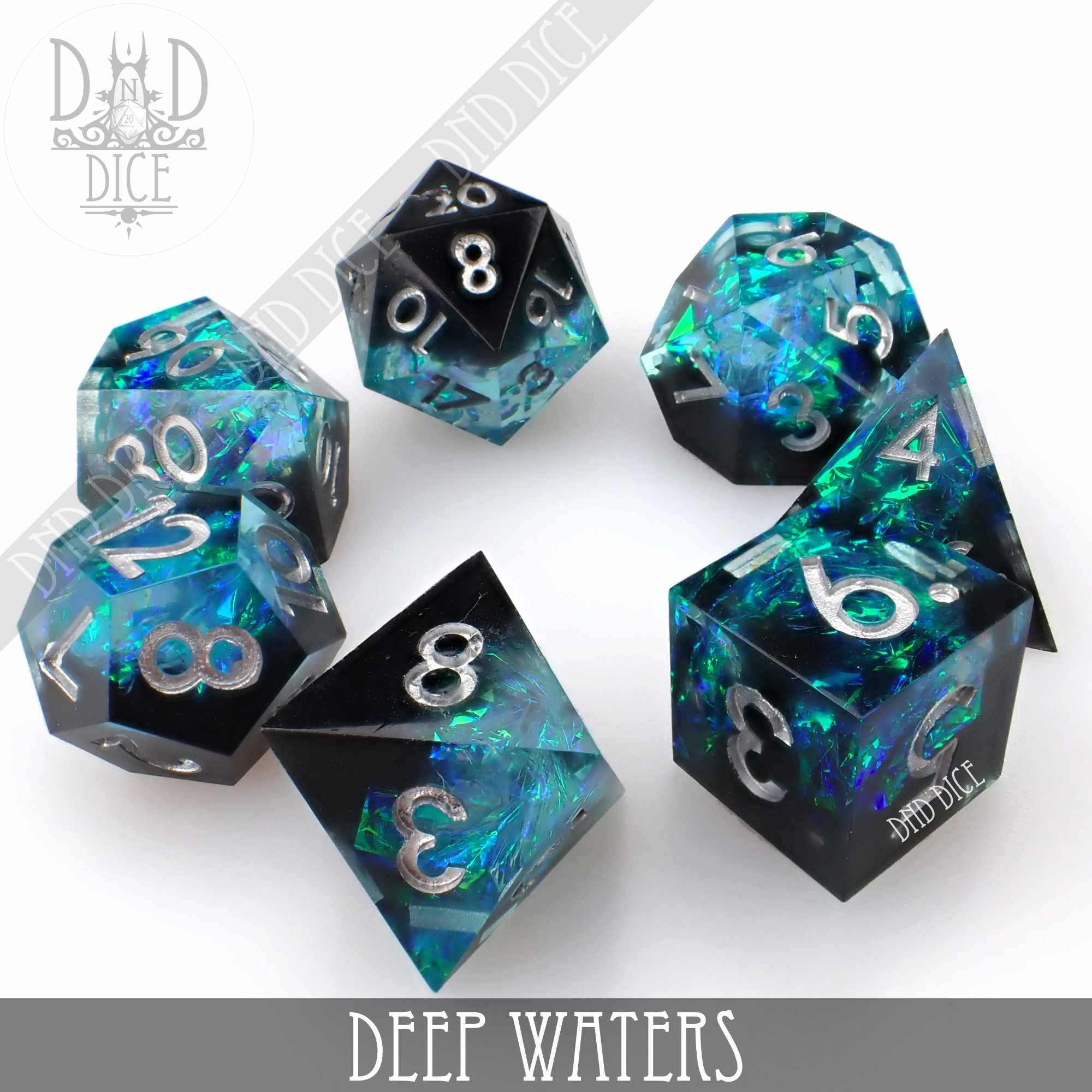 7-piece Deep Waters handmade resin dice set: black with translucent blue and green iridescent flakes, silver numbering.