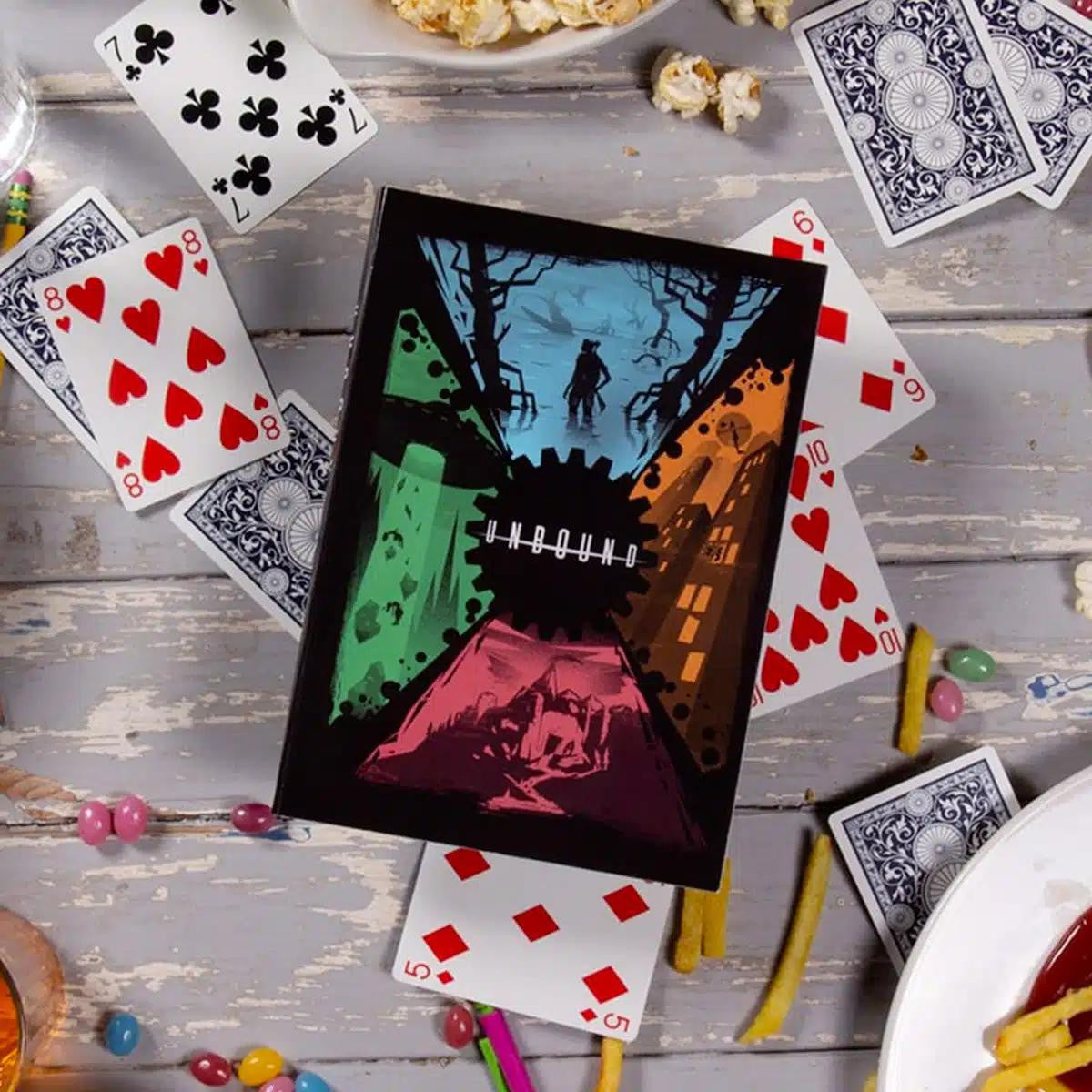 Unbound graphic novel on a table with popcorn, fries, candy, a drink, and a rules-light RPG.