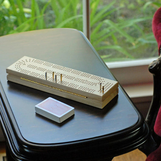 Cribbage Travel Set with pegs and cards on a black table.