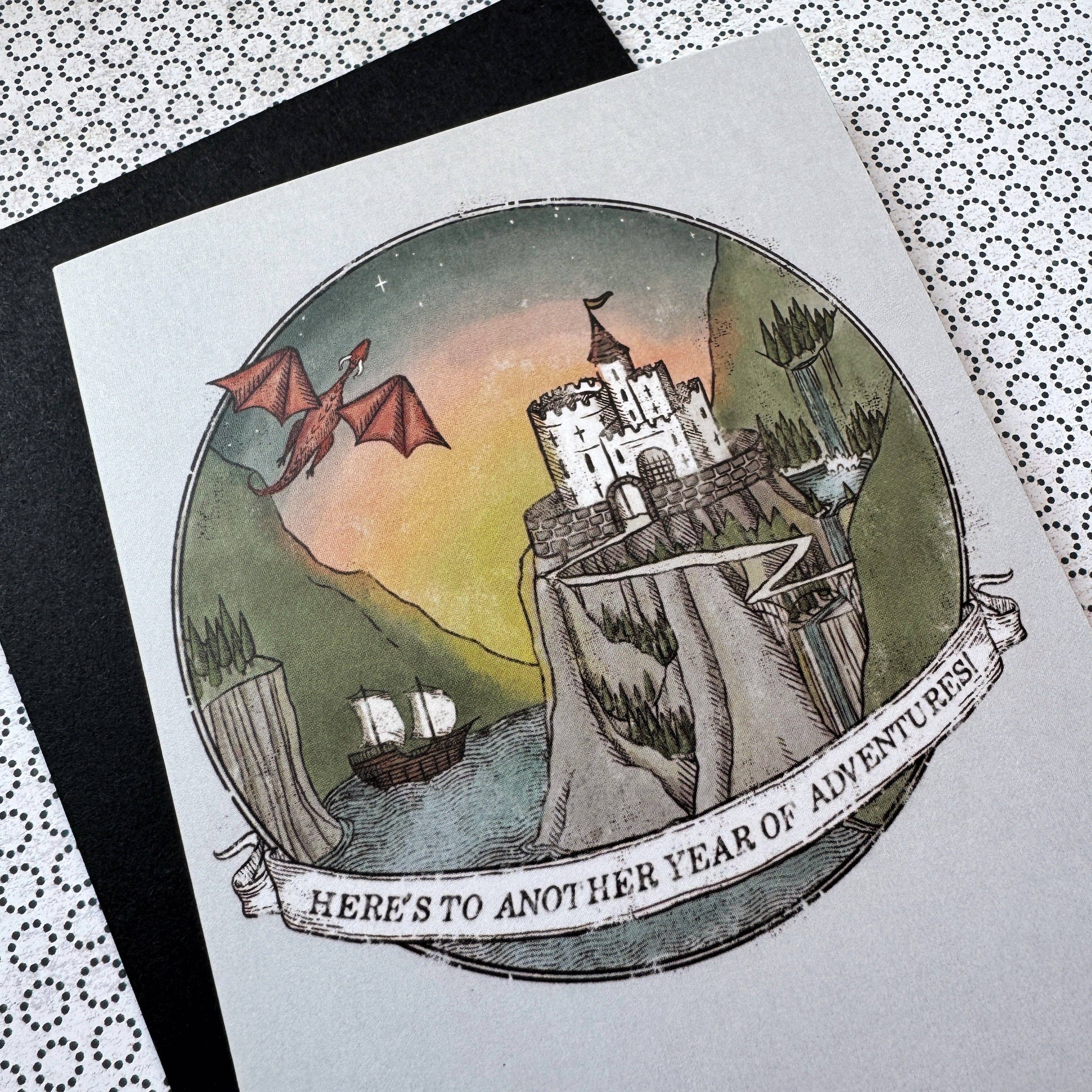 A5 D&D/fantasy birthday card featuring a dragon, castle, ship, and the text Heres to Another Year of Adventure.