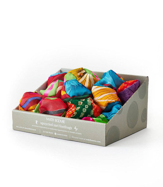 Colorful Sari Footbag Hacky Sacks in a gray cardboard tray.