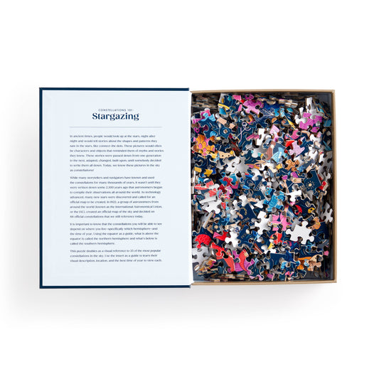 Open box of Constellations 101: Stargazing 500 Piece Book Puzzle with pieces and description sheet visible.