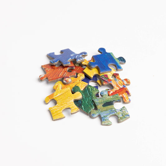 Vincent van Gogh Cafe Terrace puzzle pieces on a white surface.