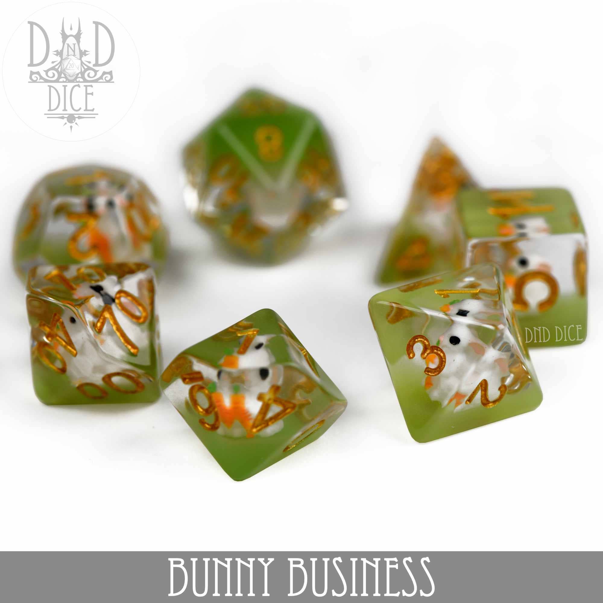Set of seven green and clear resin dice with bunny figures inside and gold numbers.