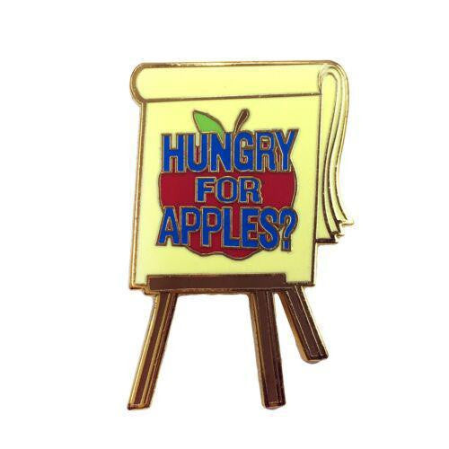 Kolorspun Hungry for Apples? enamel pin with an easel, red apple, and yellow board design.