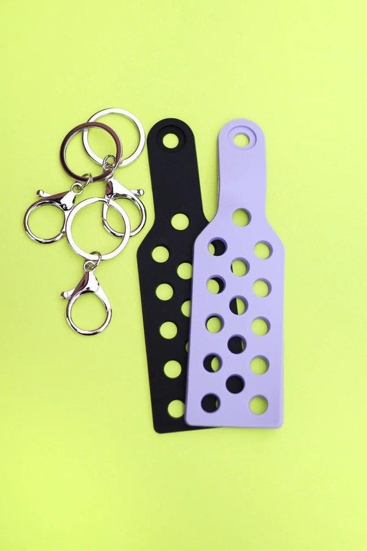 Two CHARM KEYCHAINS with metal rings, one black and one lavender.