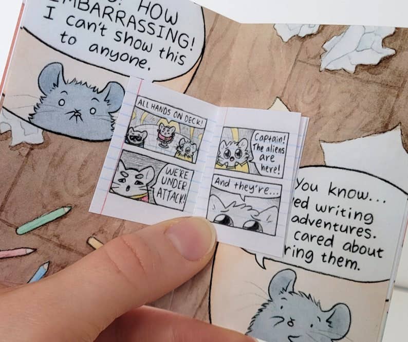 The Chinchillustrator Mini-Comic Zine held open, pages show illustrated mice encountering an alien.