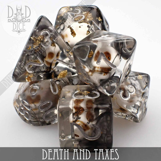 Death and Taxes 7-piece translucent resin polyhedral dice set with embedded skulls and gold flakes.