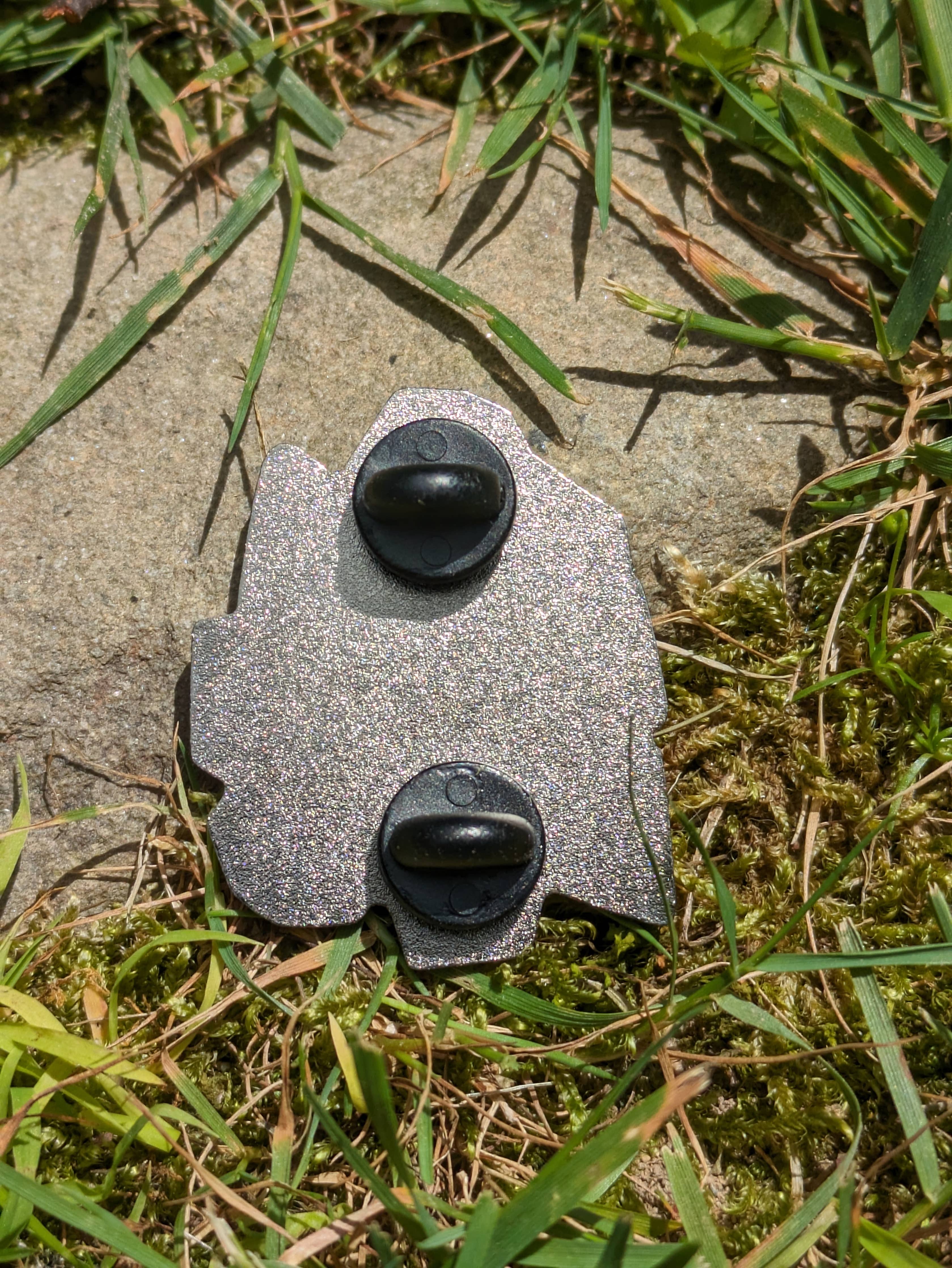 The Cat Amongst Dice 1.5 hard enamel pin with two black clasps.