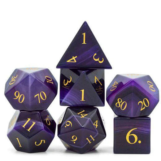 Cats Eye Mauve gemstone dice with gold engraved numbers, stacked.
