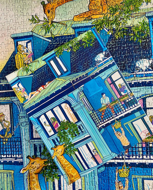 The City Culture 1000-piece puzzle for adults featuring Jules Monson’s blue house with giraffes in the windows.