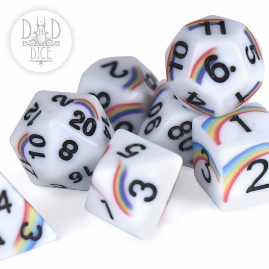 7-piece white acrylic dice set with black numbers, rainbow designs, and a logo in the corner.