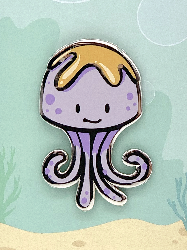 Peanut Butter Jellyfish Enamel Pin showing a purple jellyfish with a yellow top and a smiling face.