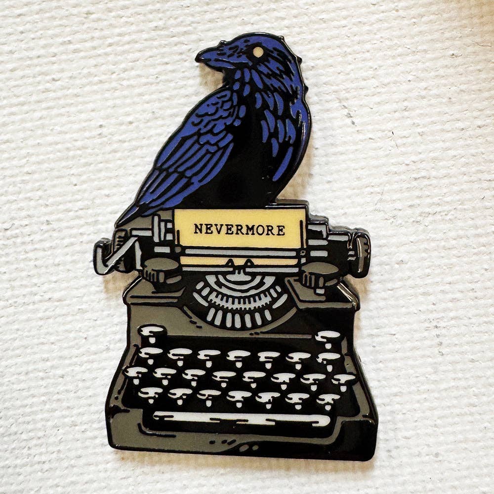 Nevermore Raven pin: blue raven on a typewriter with NEVERMORE paper, black nickel finish.