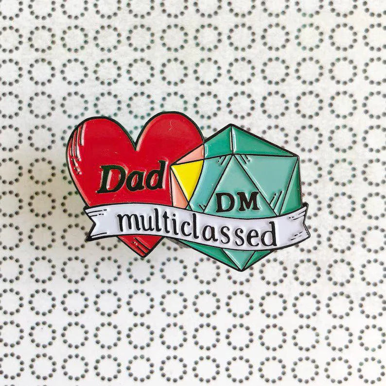 Dad DM Multiclassed D&D enamel pin featuring a DM die, heart, and black-dyed banner.