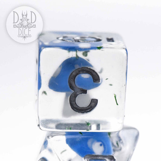 Fungal Field clear resin die with blue and green inclusions, showing the number 3.