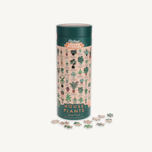 The Houseplants 1000 Piece Jigsaw Puzzle with plant-themed artwork and loose puzzle pieces.