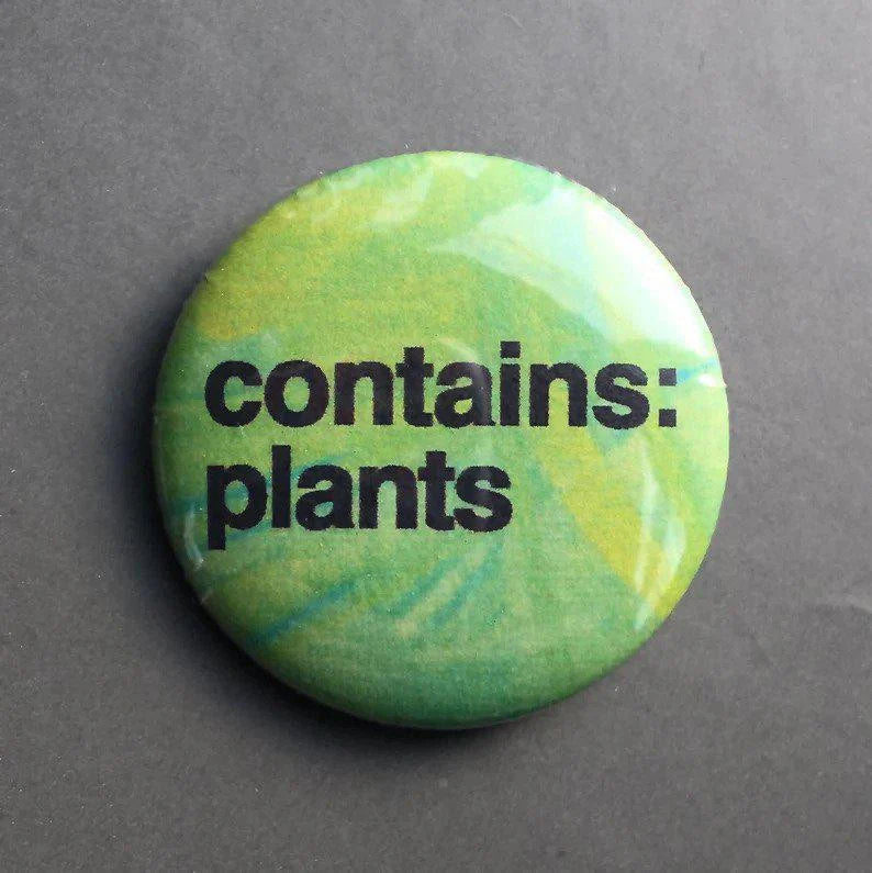 1.25 Contains Plants button pin with bold black text on a green background.