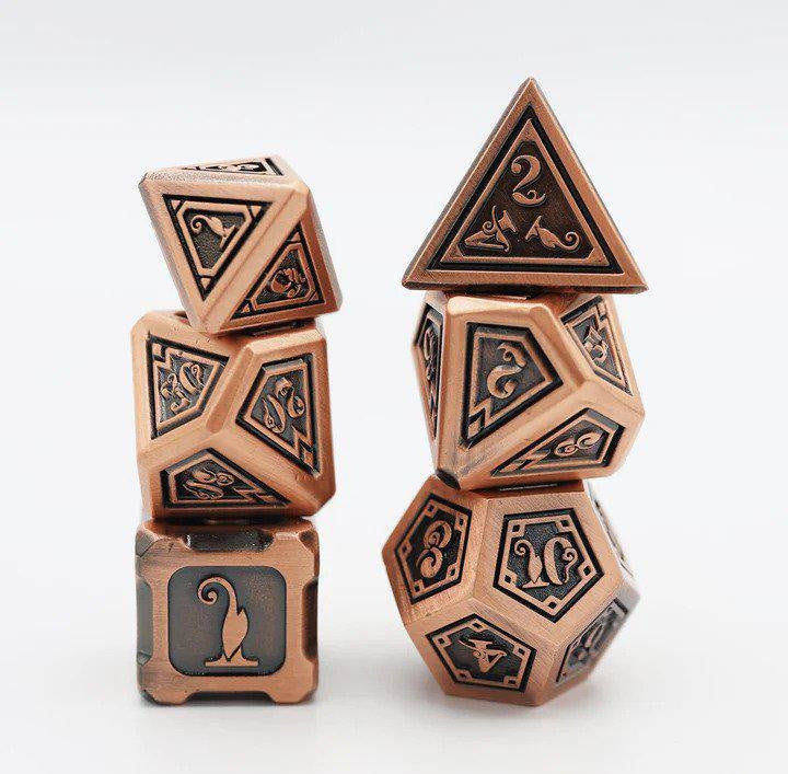 The Alchemist Metals RPG Dice Set: Copper includes two stacks of dice with engraved numbers and decorative designs.