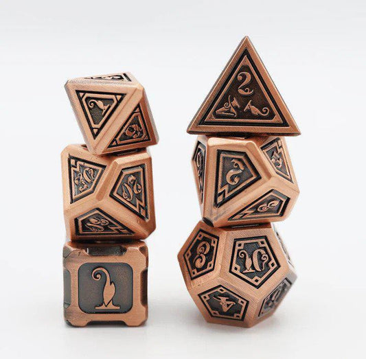 The Alchemist Metals RPG Dice Set: Copper includes two stacks of dice with engraved numbers and decorative designs.