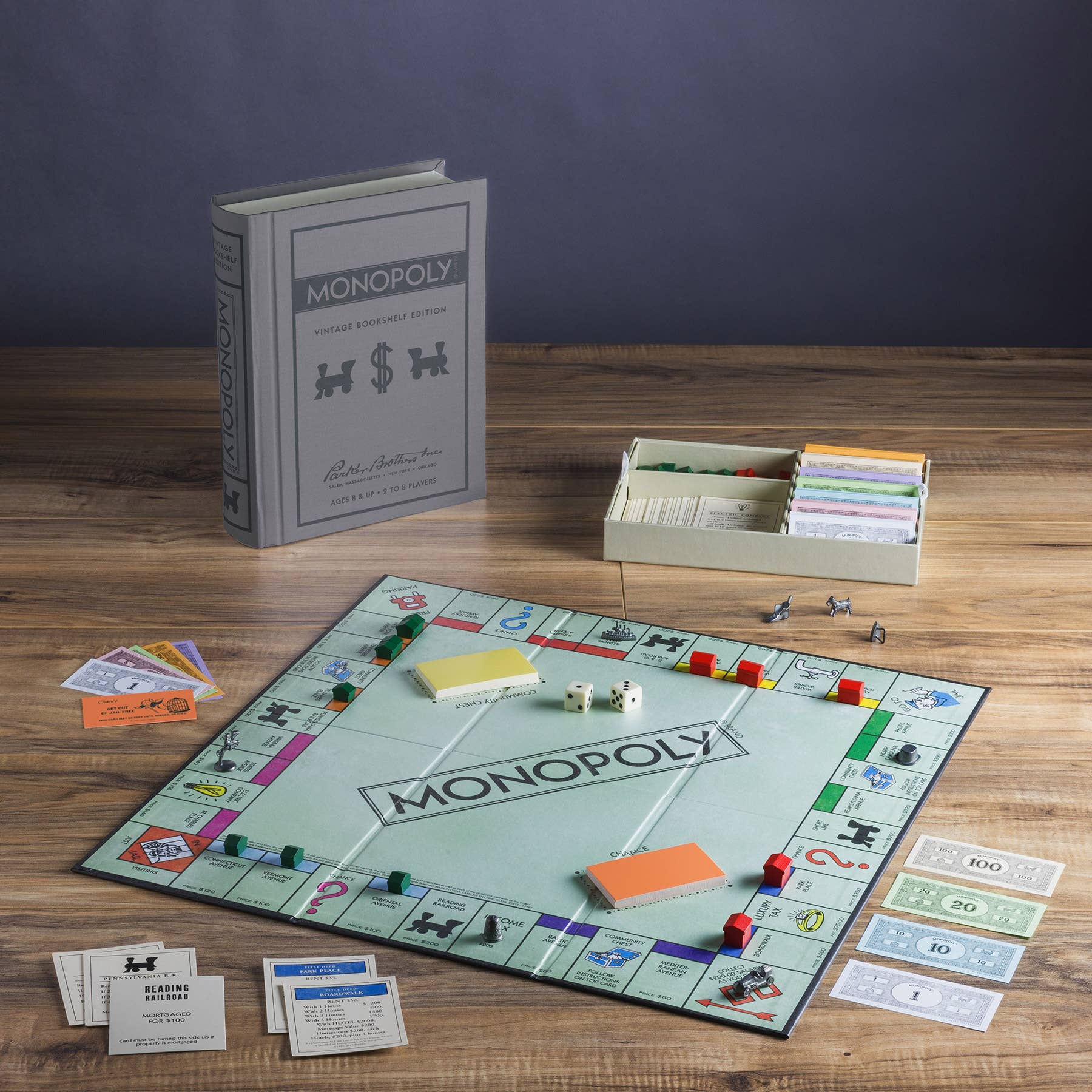 Monopoly Vintage Bookshelf Edition with cards, money, dice, and tokens; box resembles a vintage book.