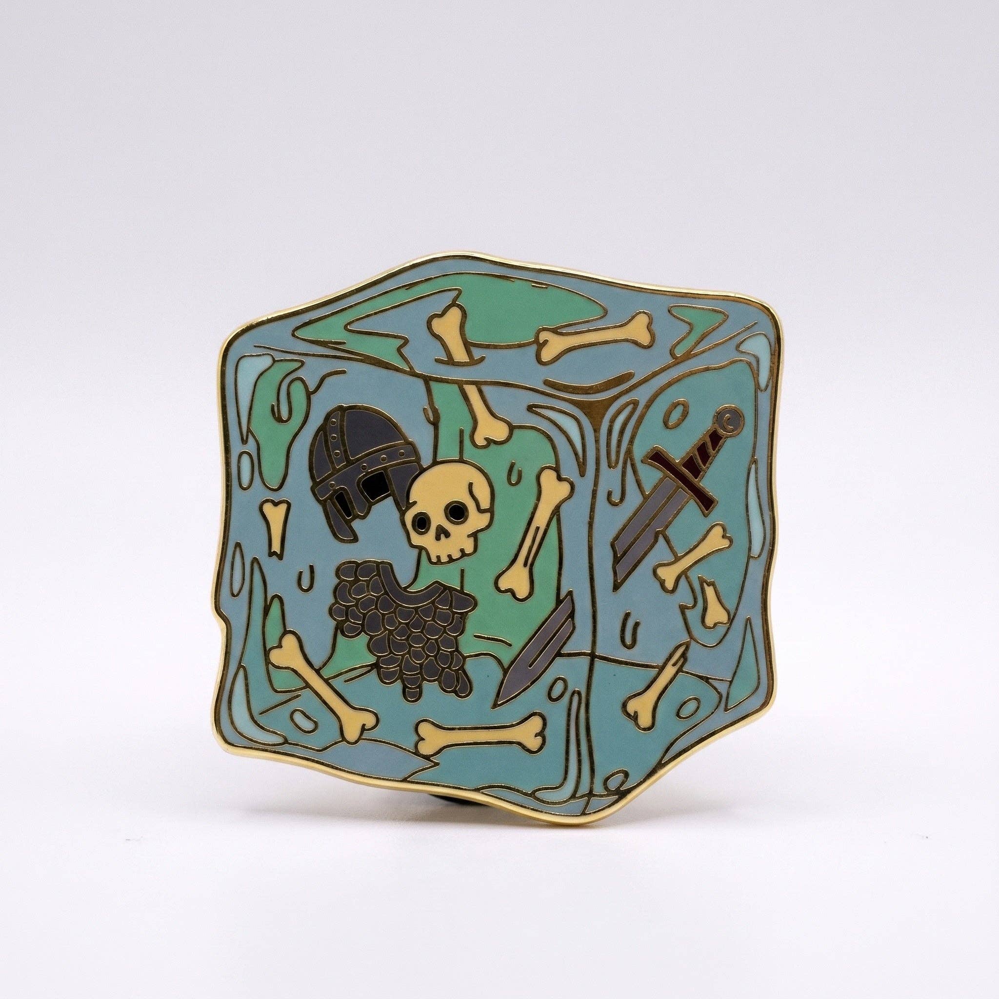 Gelatinous Cube enamel pin: gold-plated, featuring a skull, helmet, and sword inside a translucent blue resin cube.