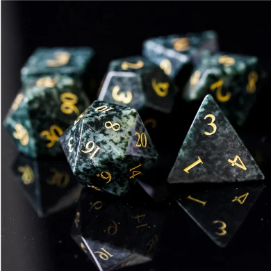 The Algal Gemstone - Engraved with Gold RPG dice set from Foam Brain Games on a black reflective surface.