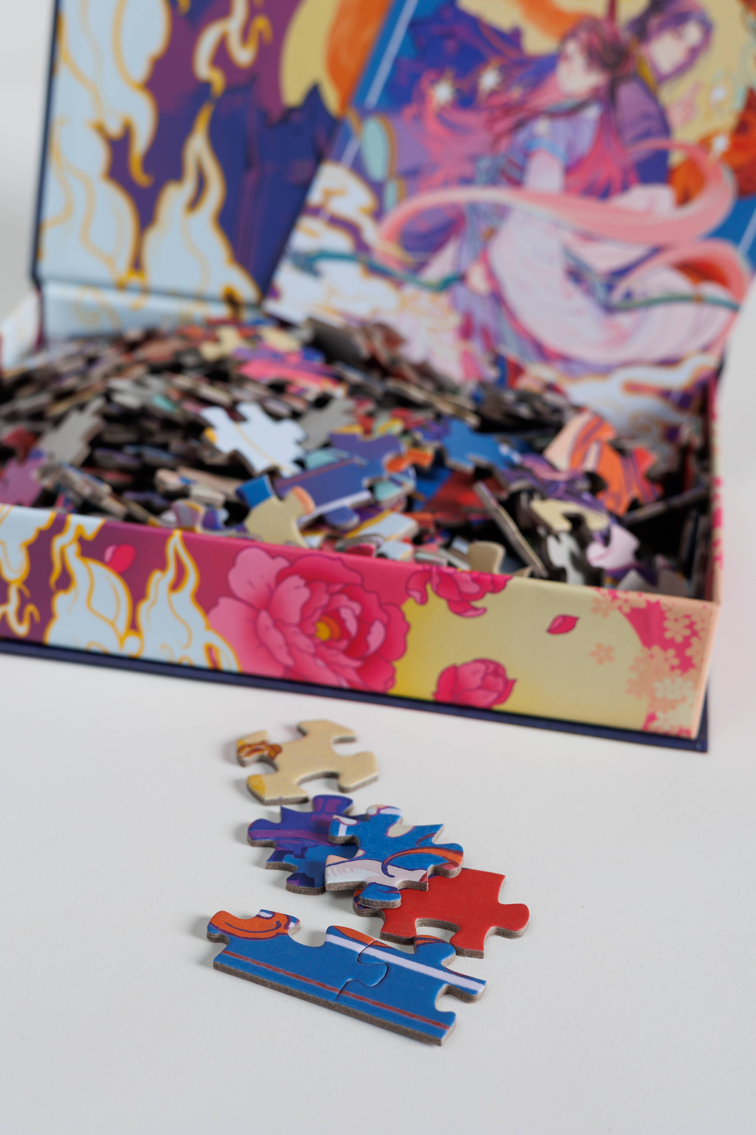 The Daughter of the Moon Goddess Keepsake Puzzle box open with floral puzzle pieces displayed on a white surface.