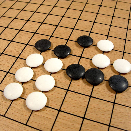 12-inch wooden GO game with plastic stones set up in gameplay formation on a wood veneer board.