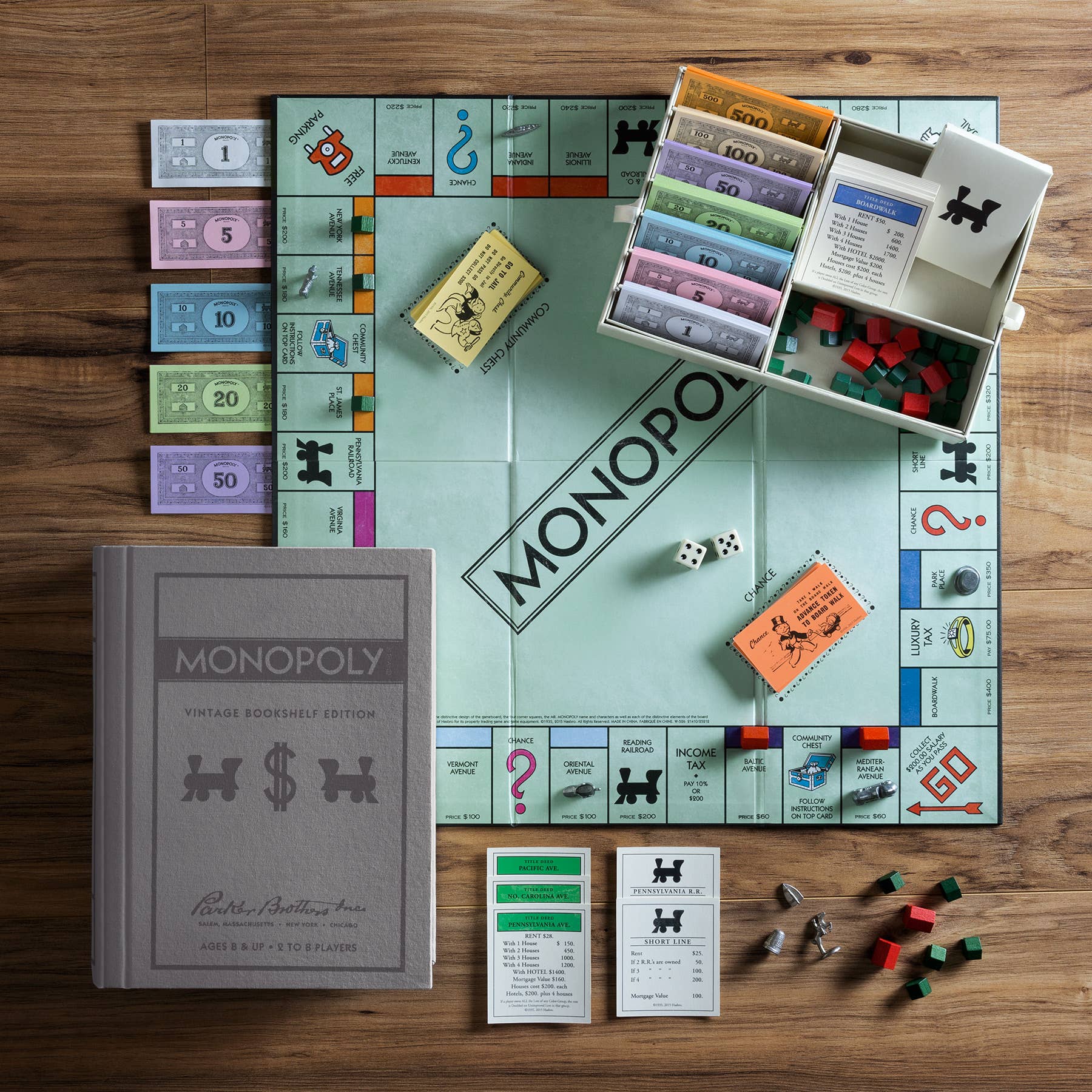 Monopoly Vintage Bookshelf Edition and premium components displayed with its vintage box on a wooden table.