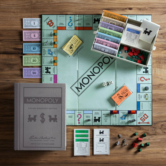 Monopoly Vintage Bookshelf Edition and premium components displayed with its vintage box on a wooden table.