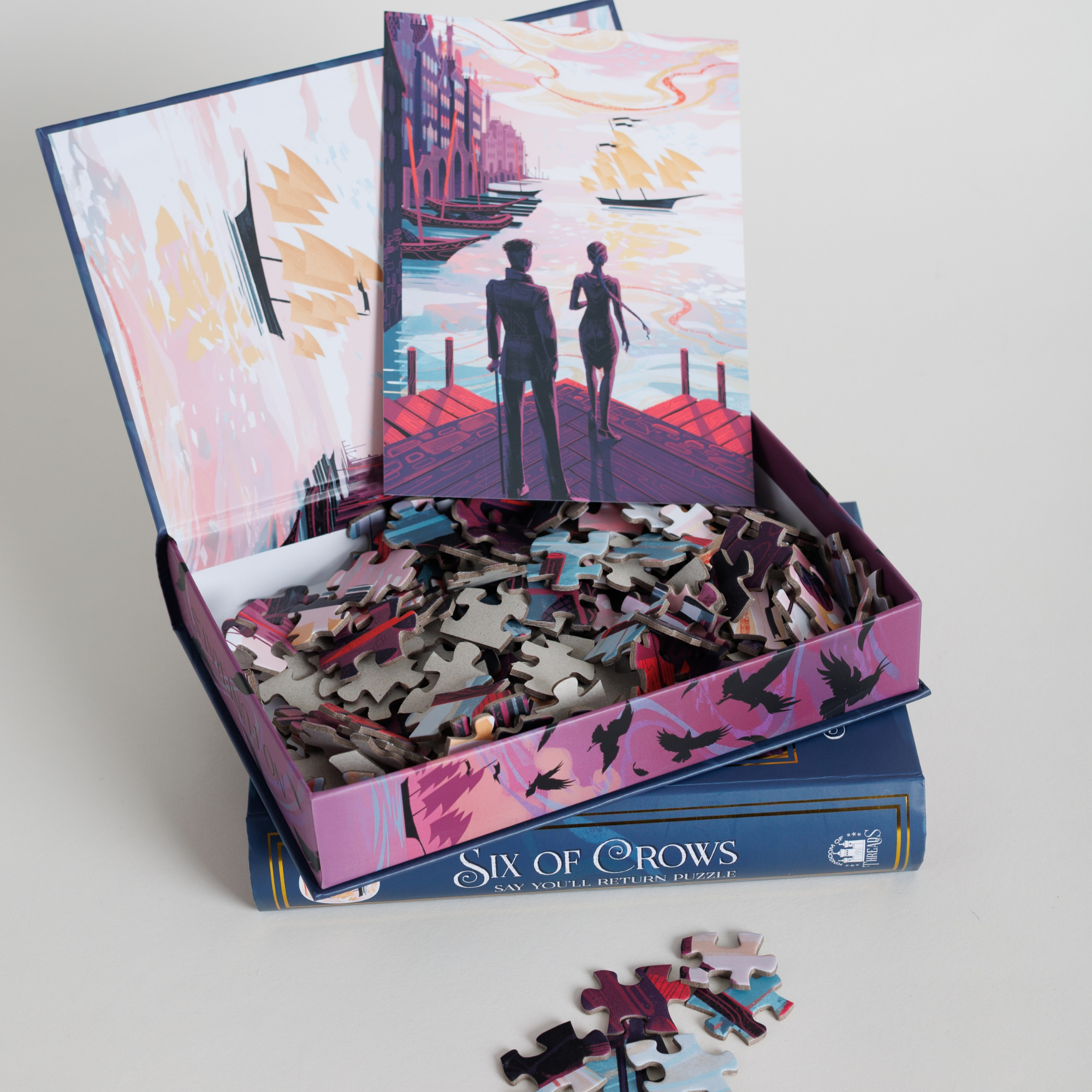 Say You’ll Return Keepsake Puzzle | Six of Crows box, open to show puzzle and art of two figures by a canal.