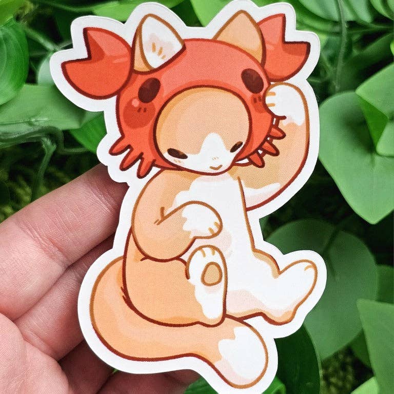 Cats in Sea Creature Costumes sticker showing a cat in an orange axolotl hoodie, held in a hand.
