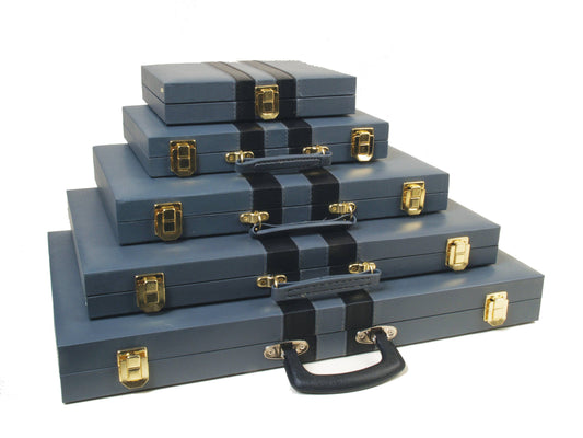 Five blue 9 Mag Backgammon cases stacked, each featuring black handles and gold clasps.