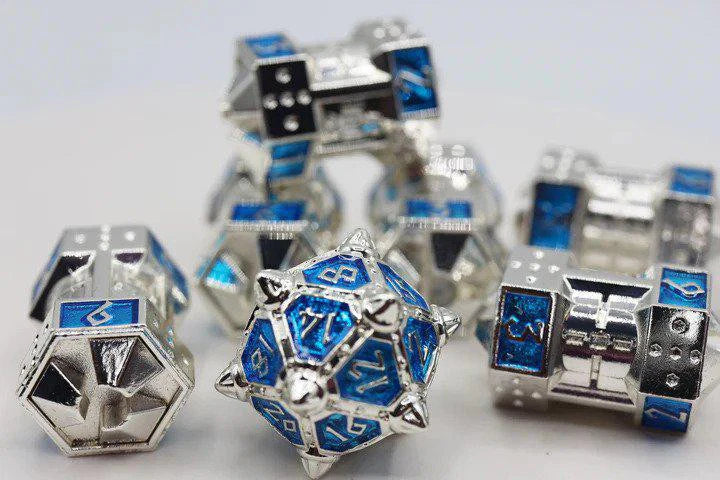 The Dice 51: Interstellar Indigo CCG Metal Dice Set with shiny silver and blue UFO-themed metal dice and a d20.