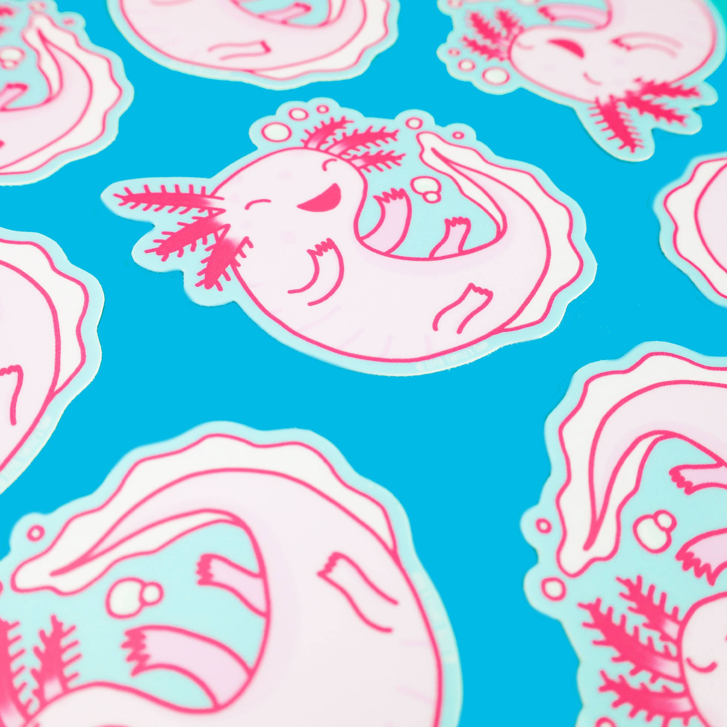 Axolotl Pink Amphibian Cute Animal Vinyl Sticker featuring cartoon pink axolotls smiling and swimming on blue.