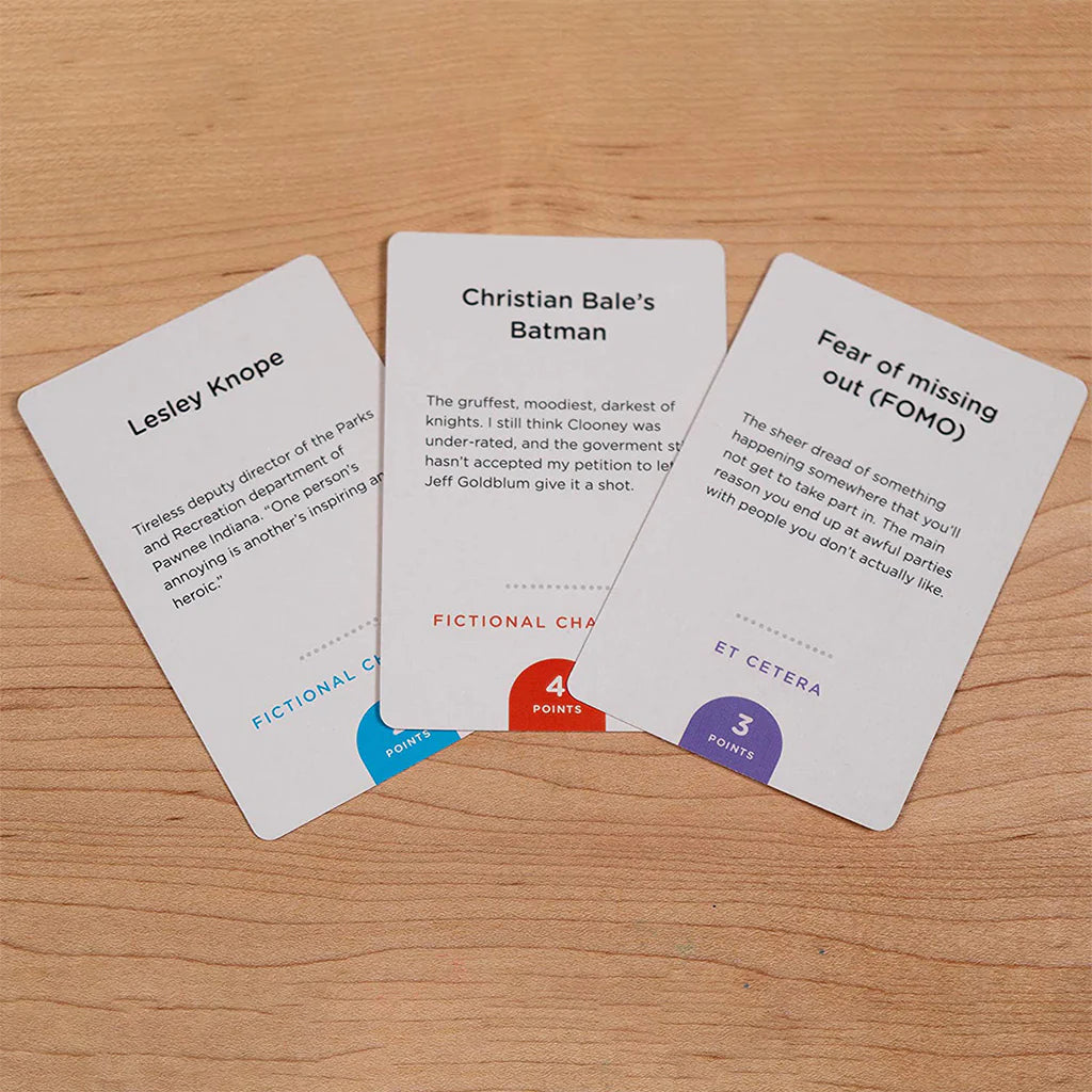 Three Monikers: Serious Nonsense expansion cards with unique text and colored point values in circles.