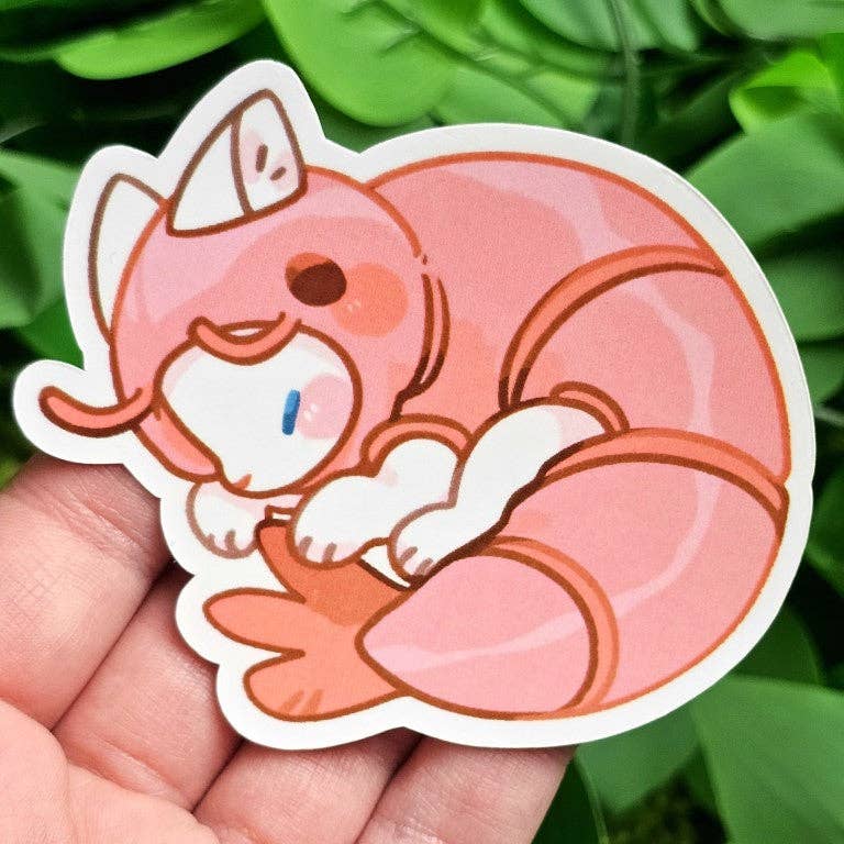 Cats in Sea Creature Costumes Sticker showing a cat in a pink shrimp suit, with green leaves in the background.