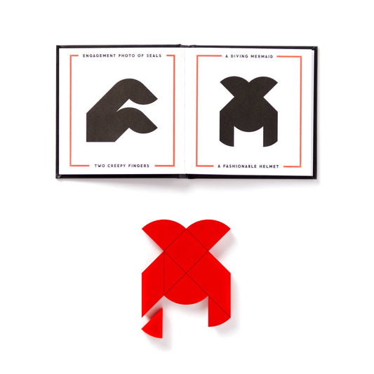 Brass Monkey At First Sight Tangram Puzzle with heart-shaped pieces arranged over an open book as shown in the book.