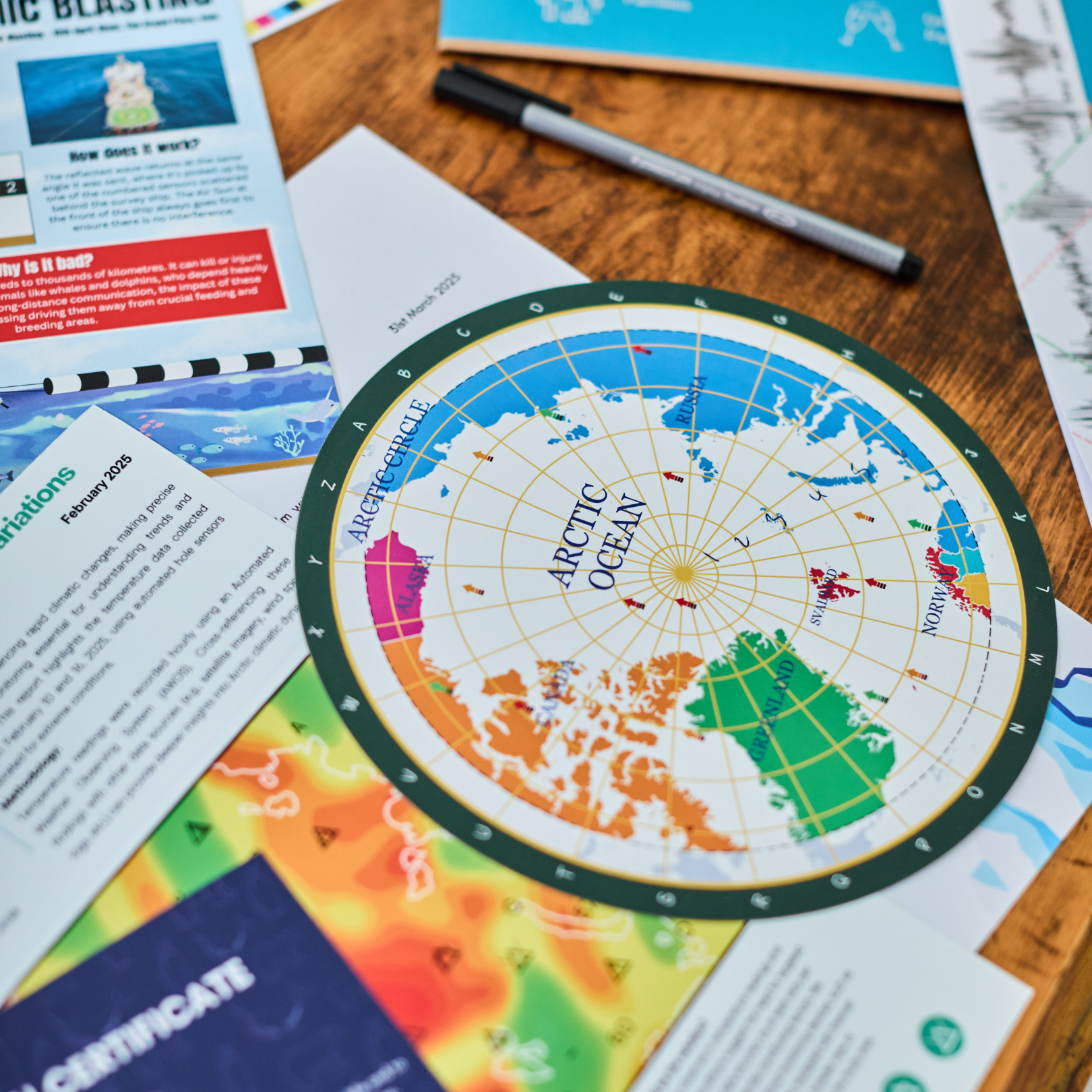 Escape Room in An Envelope: The Disappearance game with Arctic Ocean map, brochures, and pen.
