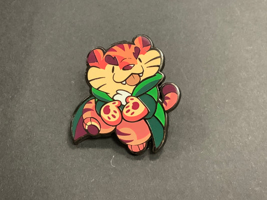 Heliana Sunsnacker/Tiger pin featuring cartoon tiger with orange-red stripes and green cape on black background.