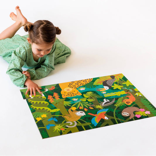 Wild Rainforest 24-Piece Floor Puzzle being assembled on a white surface by a young girl in a green dress.