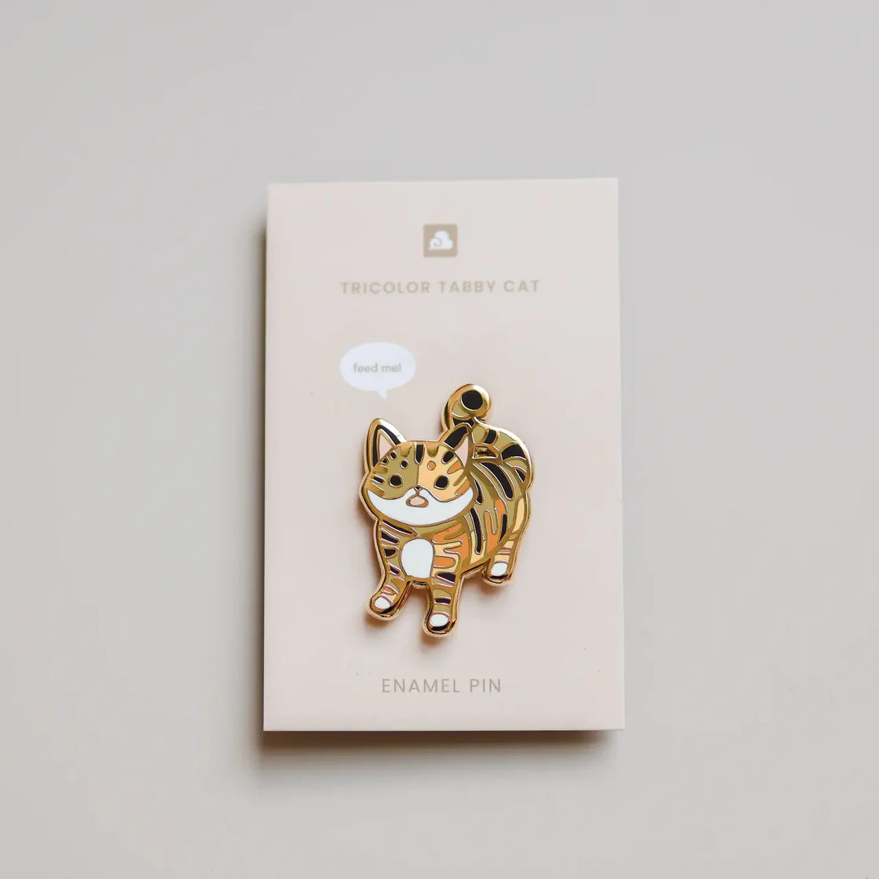 Tricolor Tabby Cat Enamel Pin showing a tricolor tabby cat, attached to a product name card.