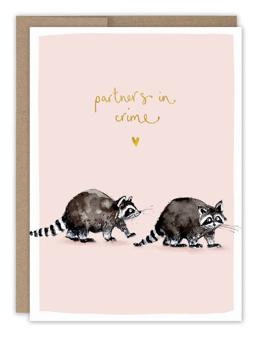 Partners In Crime Love Card with two raccoons on a pink background and “partners in crime” text, blank inside.