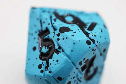10-sided Blue Quarry Metal RPG dice with engraved black numbers and black speckles.