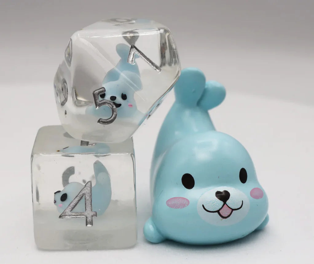 Blue Seal RPG Dice Set with two clear resin dice containing blue seal figures, shown next to a small blue seal toy.