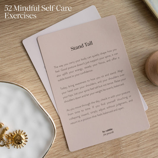Self-Care & Affirmations card with jewelry and intention cards nearby on a wooden surface.
