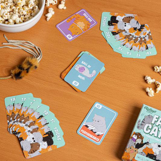 Fat Cats board game on wooden table with popcorn and toy mouse, played by cat lovers.